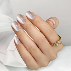 Elegant nude ombre nail design with glossy finish, featuring a gold ring with floral embellishments.