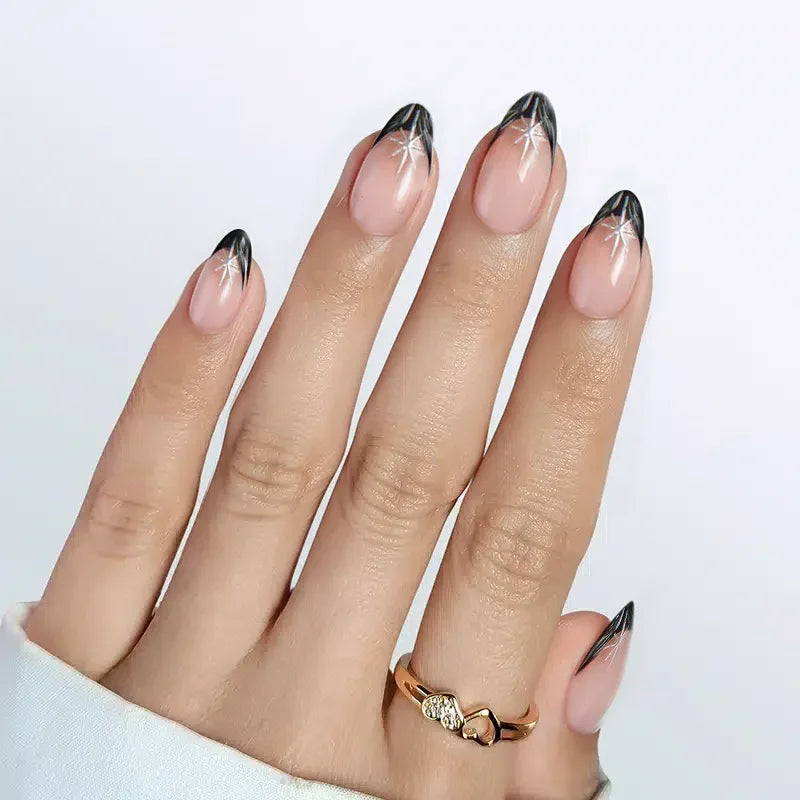 Elegant almond-shaped nails with black tips and star designs, perfect for casual or formal occasions.