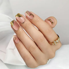 Stylish nude nails with gold tips and accents, showcasing elegant design and manicure perfection.
