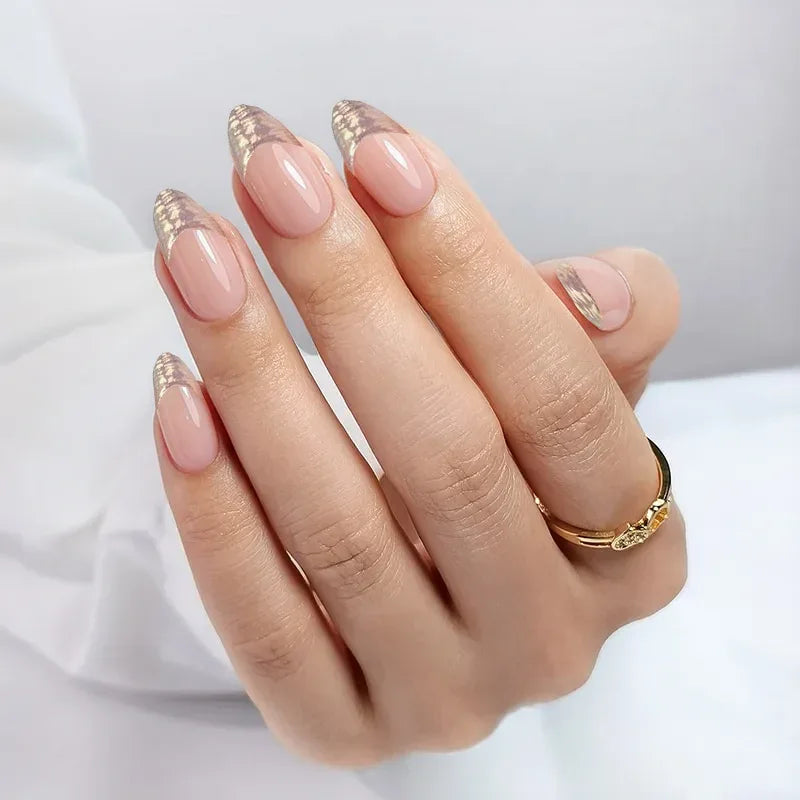 Elegant nude almond-shaped nails with gold tips, perfect for stylish manicures.