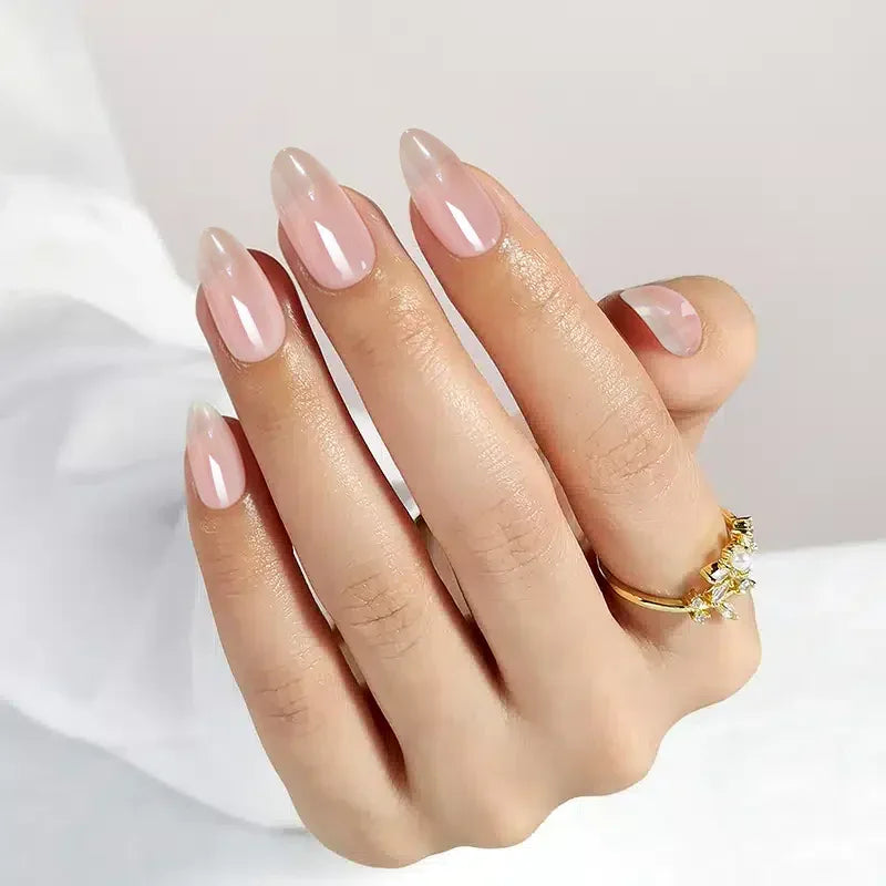 Elegant pink almond-shaped nails with a glossy finish, complemented by a gold ring.