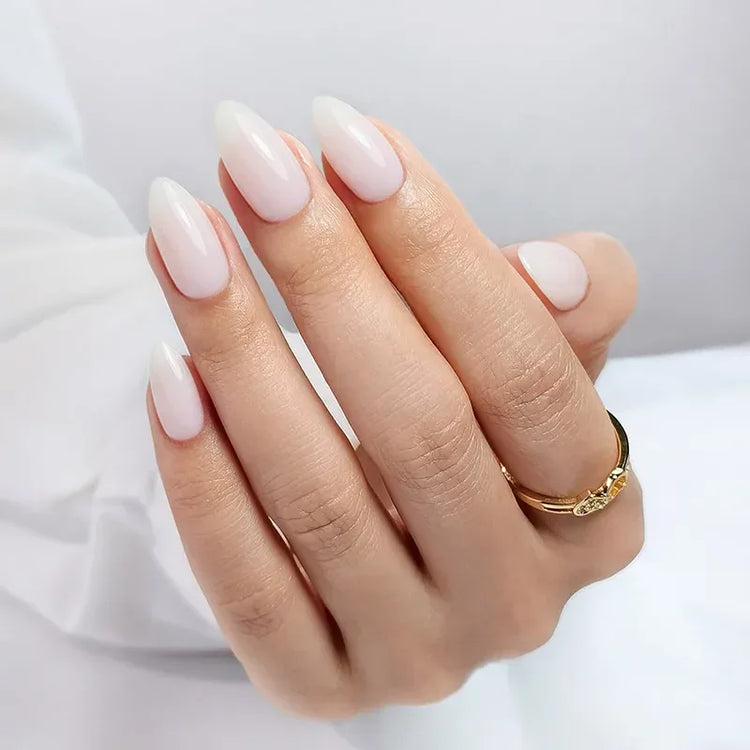 Elegant white almond-shaped acrylic nails with a glossy finish and gold ring accent.
